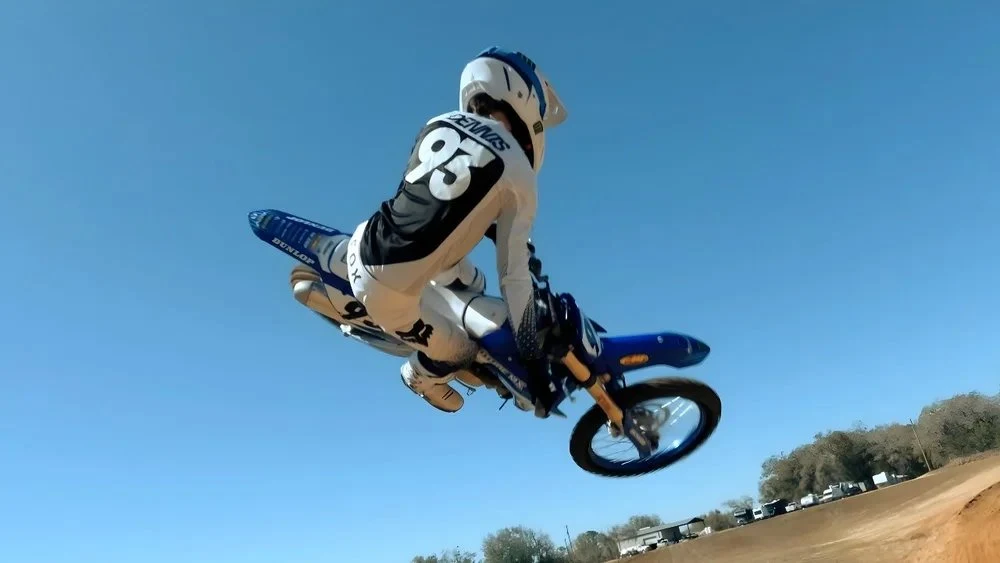 Motocross rider airborne against a clear sky