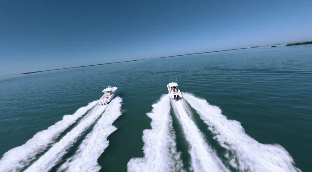 Two boats leaving long wakes across open water