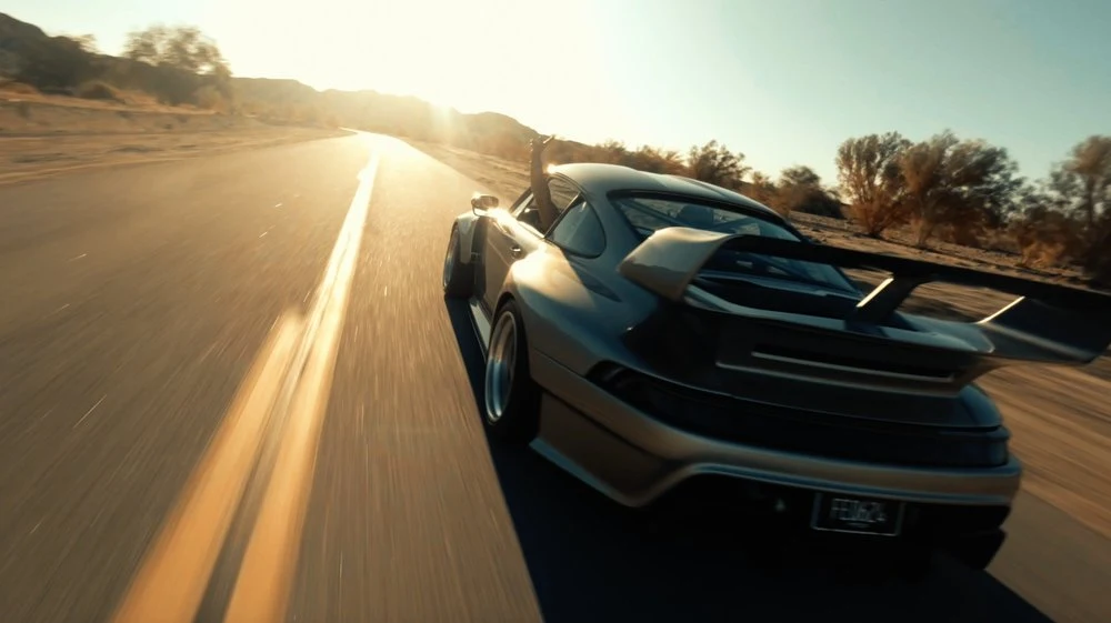 Sports car driving into golden evening light
